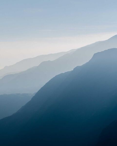 Example to enhance: Hazy blue mountain ridges fading into the distance