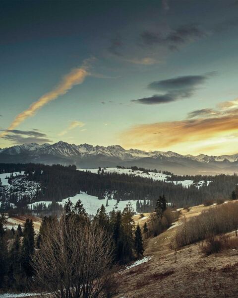 Example to enhance: A snow-dusted valley and mountain range at sunset